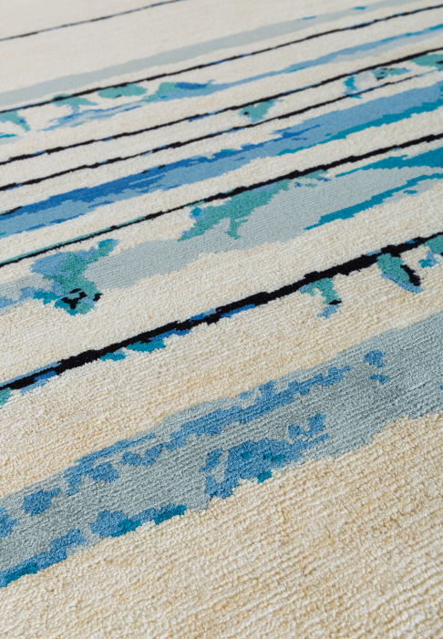 TAPIS-BRINDILLE-RECT-detail2.jpg Tapis blanc avec lignes horizontales bleues, gros plan